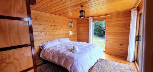 a bedroom with a bed in a wooden cabin at Cabana Chiloe in Queilén