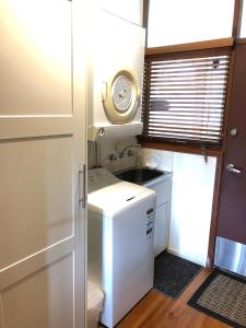 a small kitchen with a sink and a refrigerator at The Green Room Wattle Glen in Wattleglen