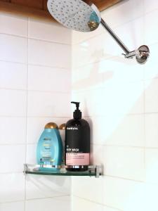 a shelf in a bathroom with soap and shampoo at The Green Room Wattle Glen in Wattleglen +32 photos