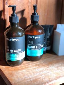 two bottles of hand lotion sitting on a wooden shelf at The Green Room Wattle Glen in Wattleglen