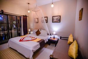 a hotel room with a bed and a table at The Sanctuary Villa Battambang in Battambang