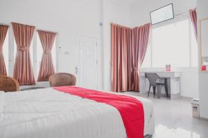 占碑市RedDoorz Syariah near Arafah Hospital Jambi的卧室里有一张床，床上铺着一条红毯子