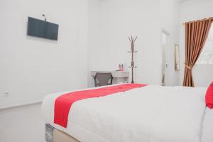 占碑市RedDoorz Syariah near Arafah Hospital Jambi的白色客房,配有一张带红色毯子的床 更多5张照片