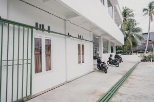占碑市RedDoorz Syariah near Arafah Hospital Jambi的停在大楼外的一组摩托车