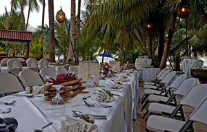 a table set up for a wedding with white chairs at Costabella Tropical Beach Hotel in Mactan