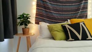 a bed with pillows and a plant on a table at No.6 The Ease @ The only Bohemia Style at Puchong in Puchong +35 photos