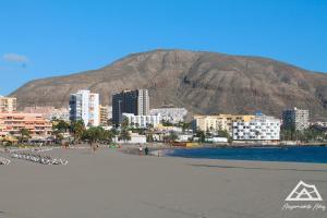 een uitzicht op een strand met een berg op de achtergrond bij Alojamiento Alby: Oceano in Los Cristianos