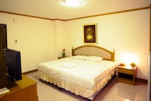 a bedroom with a bed and a flat screen tv at The Residence Hotel -SHA Extra Plus in Chiang Mai