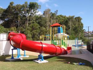 um parque infantil com um escorrega vermelho num parque em Ingenia Holidays Bonny Hills em Bonny Hills