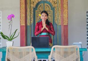 a woman standing in front of a table with a laptop at La Numa Villas Canggu in Canggu