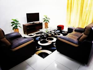 uma sala de estar com dois sofás e uma mesa em A&D Home-stay @Kota Warisan, Sepang (KLIA 15 min) em Sepang