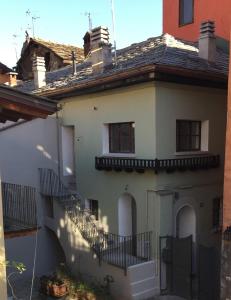 a white house with stairs and a balcony at Aubert 64 in Aosta