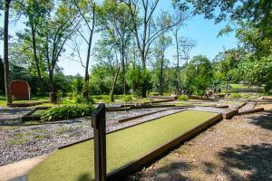 um parque com relva verde, bancos e árvores em Hershey Camping Resort Park Model 6 em Mount Wilson