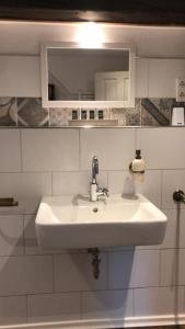 een badkamer met een witte wastafel en een spiegel bij Ostland-Loft in Borkum