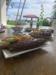 a table with two trays of food on it at Looking Good Beachfront Hotel in El Zonte