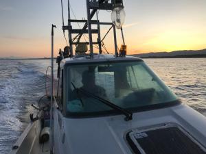 a boat in the water with the sunset in the background at B&B MIKAWA - Kanazawa Fish Harbour in Mikawa