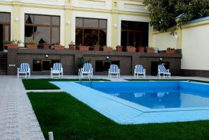 a group of chairs sitting next to a swimming pool at Jahon Palace in Samarkand