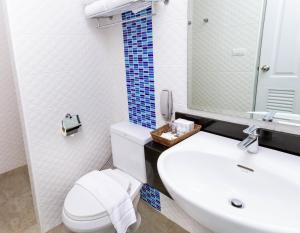 فندق باتايا إف إكس في جنوب باتايا: حمام به مرحاض أبيض ومغسلة