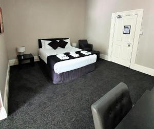 
a bedroom with a white bed and a white bedspread at Grand Hotel in Newcastle
