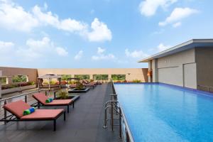 a pool at a hotel with lounge chairs at Welcomhotel by ITC Hotels, GST Road, Chennai in Singapperumālkovil