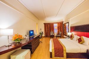 Pokój hotelowy z łóżkiem i biurkiem w obiekcie The South Park Hotel w mieście Thiruvananthapuram