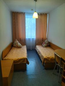 a hotel room with two beds and a window at Sanatoriy Zhosaly in Qarqaraly