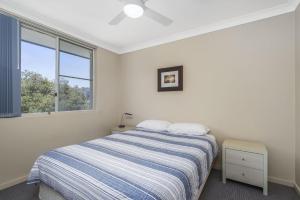 ein weißes Schlafzimmer mit einem Bett und einem Fenster in der Unterkunft Maliblue, 5/1 Main Street, Crescent Head in Crescent Head