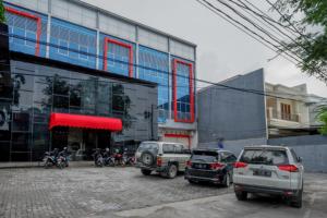 een groep auto's geparkeerd voor een gebouw bij RedDoorz @ Jalan Kartini Semarang in Semarang