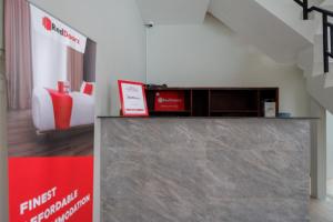 a lobby with a reception desk and a couch at RedDoorz @ Jalan Kartini Semarang in Semarang