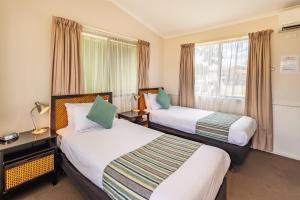 Emu Plains的住宿－比格斯尼皮恩河假日公園，酒店客房设有两张床和窗户。