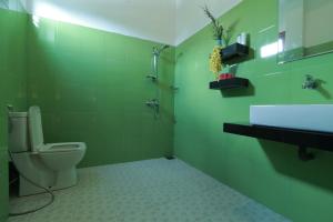 a green bathroom with a toilet and a sink at Hotel Bay Watch Unawatuna in Unawatuna