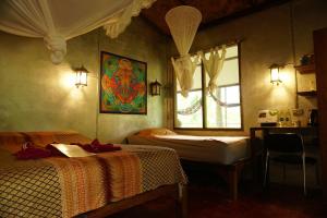 um quarto com 2 camas e uma janela em Eco-Logic, Resort for Charity em Phato