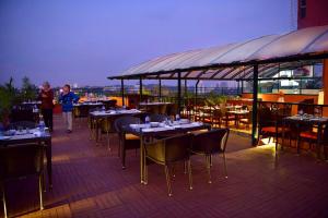 a restaurant with tables and chairs on a roof at The South Park Hotel in Trivandrum