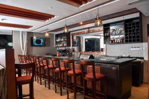 a bar with a row of bar stools in a restaurant at Hillpark Hotel in Nairobi