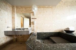 a bathroom with a sink and a granite counter top at Palm Island B&B in Gukeng