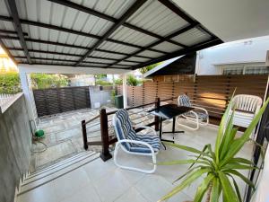 un patio con sillas, una mesa y una valla en Villa Ebène - Ideal Location in Rose Hill en Rose Hill