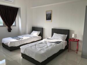 a bedroom with two beds and a red table at Apartment Suite Cyberjaya by Host Assist in Cyberjaya
