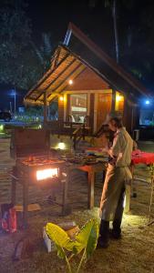 a man standing in front of a grill at night at Cocolagoon eco Resort Nilaveli in Trincomalee