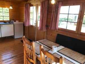 una cocina con mesa y sillas en una cabaña en Sfeervolle Blokhut, en Oostvoorne