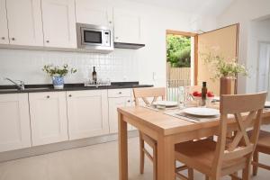 維甘的住宿－Eol Apartments Viganj，厨房配有白色橱柜和木桌