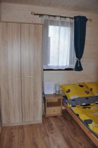 a small bedroom with a bed and a window at Domki letniskowe MagNat 700m od morza! in Rusinowo