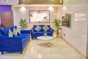 - un salon avec des canapés bleus et une table dans l'établissement Grand Square Hotel, à Dubaï