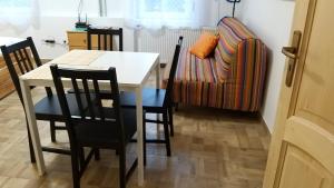a dining room with a table and chairs and a couch at Ó-Újlak Apartman in Budapest