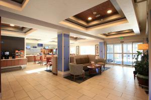 un vestíbulo de un hotel con mesas y sillas en Holiday Inn Express Hotel & Suites Ashland, an IHG Hotel en Ashland