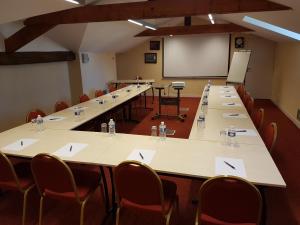 a large room with tables and chairs and a whiteboard at B&B Domaine de La Corbe in Bournezeau +42 photos