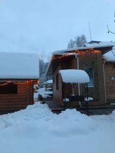 a house covered in snow with lights on it at Holiday Home Rayskiy Ugolochek in Kvitki