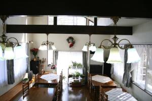 Pension Half Time في هوكوتو: غرفة طعام مع طاولة وكراسي ونوافذ