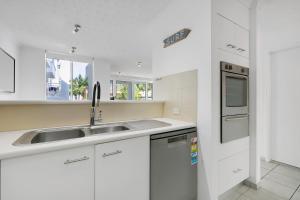 a white kitchen with a sink and a stove at The Bay 23 in Gold Coast