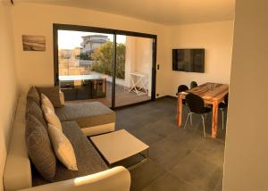 a living room with a couch and a table at Résidence Les Jardins du Fort in Porticcio