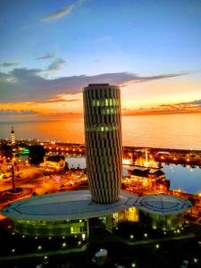 - une vue sur un bâtiment la nuit avec une ville dans l'établissement Апартамент с видом на море, à Batoumi